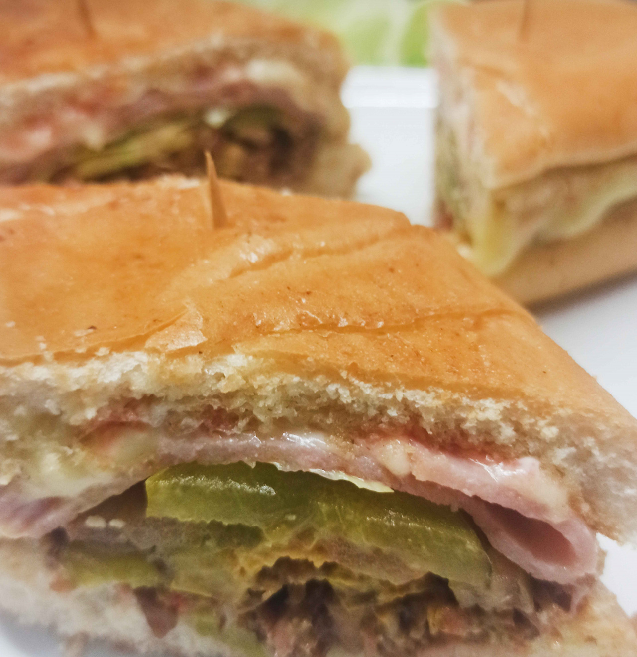 Sandwich en pan cubano con deliciosa pierna ahumada,Jamon Picnic, Queso danes, cebolla, tomate, lechuga, pepinillo, aderezado con Mostaza.