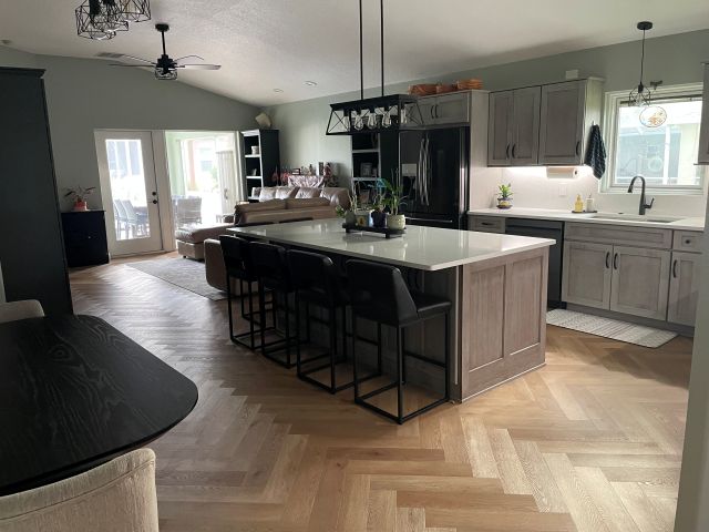 The elegant herringbone luxury vinyl plank flooring creates a striking focal point, adding warmth and texture to this beautifully designed kitchen.