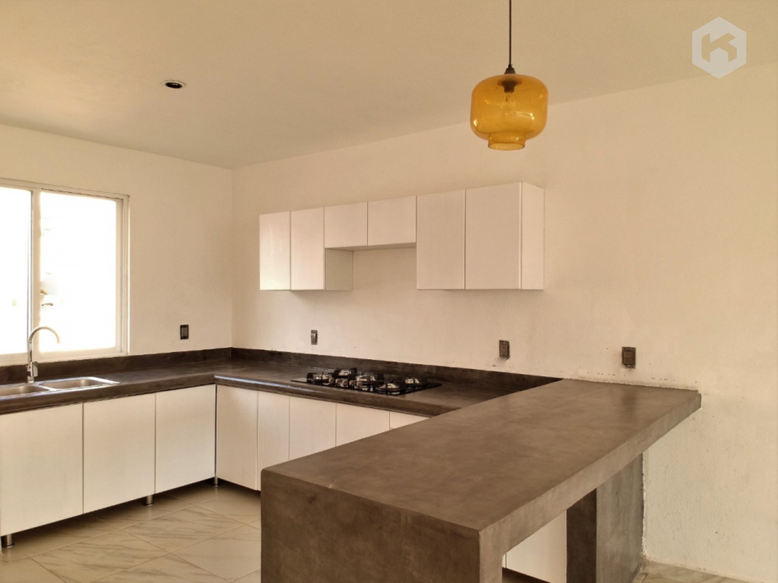 KREAR : Cocina integral en forma de L que utiliza el microcemento pulido como elemento protagonista