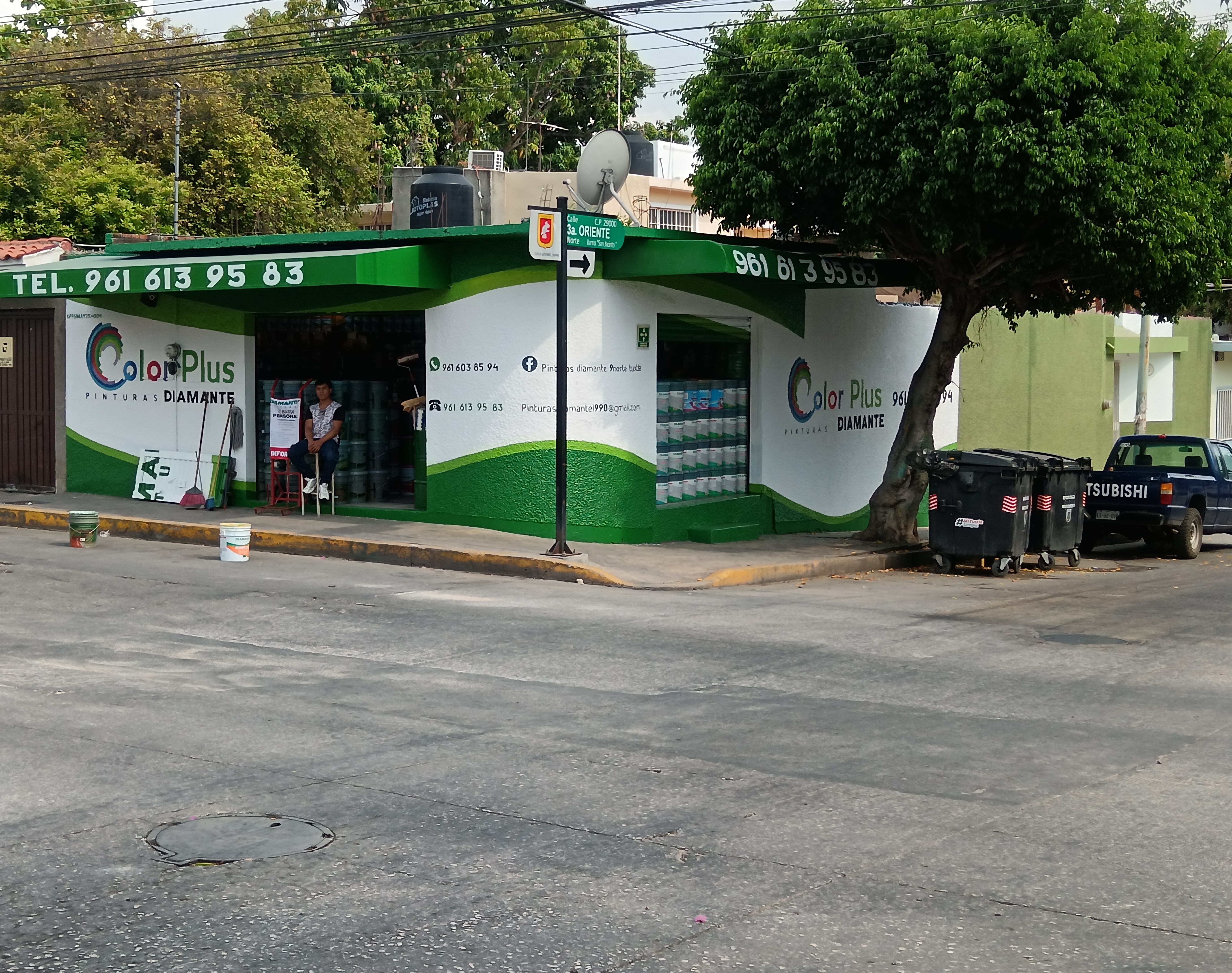 Habitación vacía con paredes pintadas de azul claro y una pared azul oscuro, suelo de mármol blanco, ventanas de cristal y puerta blanca.