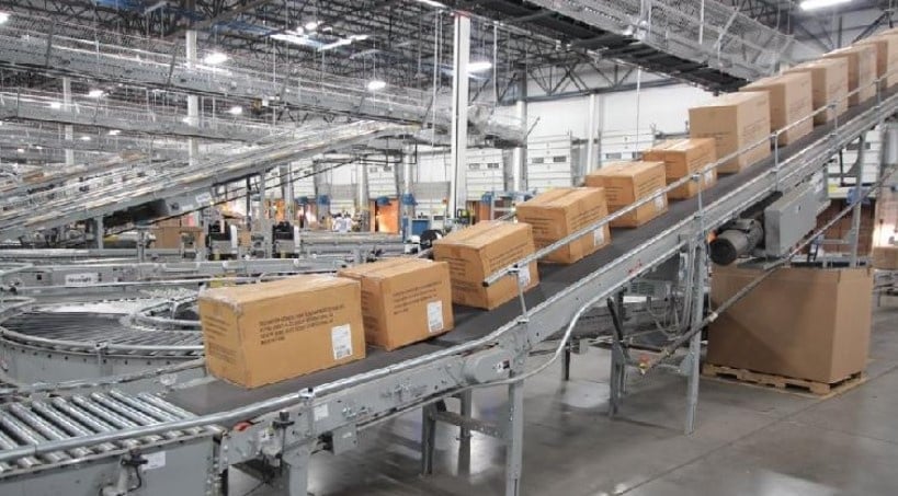 Cajas de cartón en una cinta transportadora en una fábrica o almacén industrial.