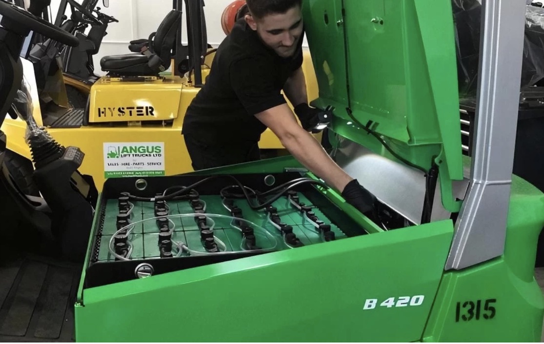 hombre con chaqueta roja y negra con casco naranja