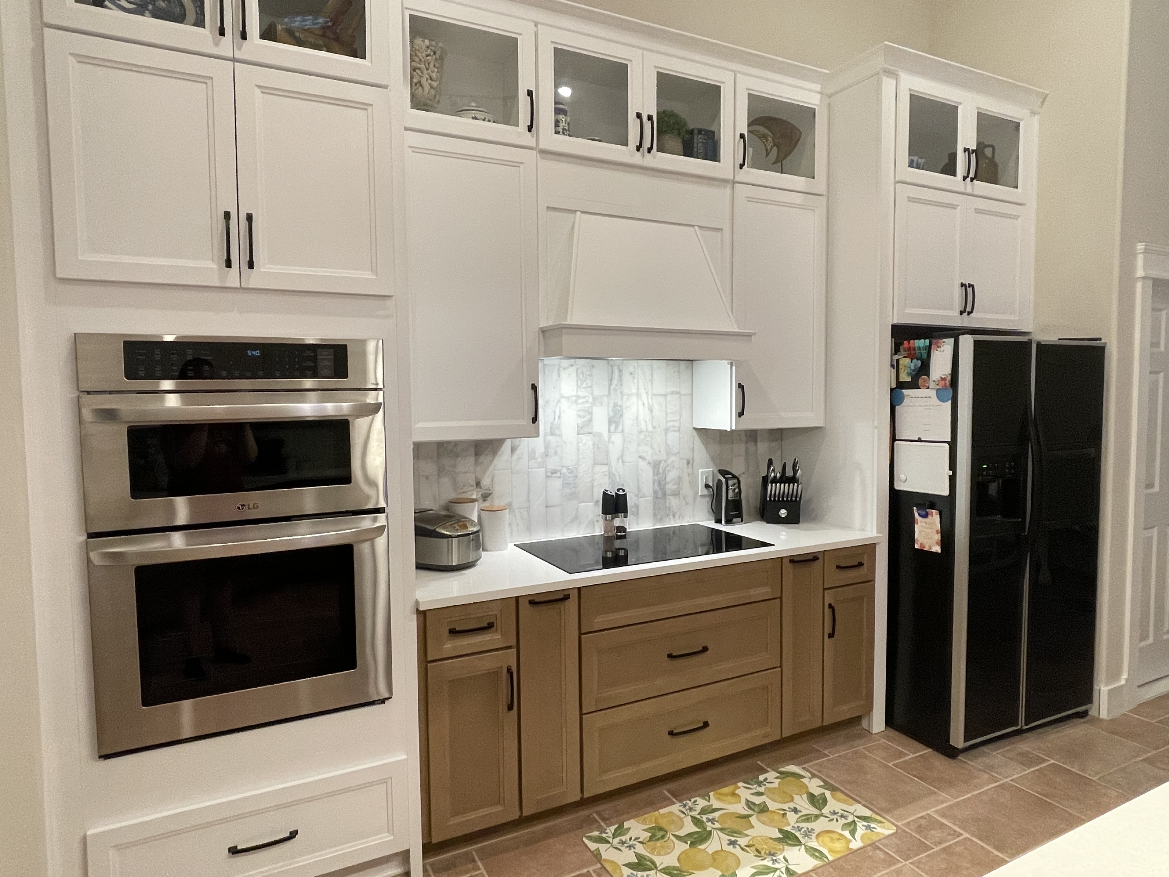 The wood hood centralizes the space and allows the painted cabinetry and backsplash to pop.