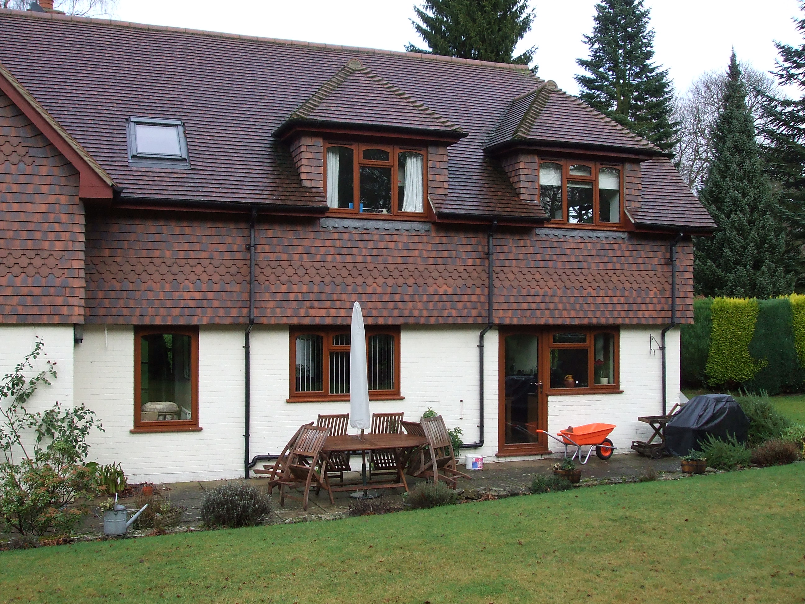 man in black t-shirt and gray pants standing near white wall