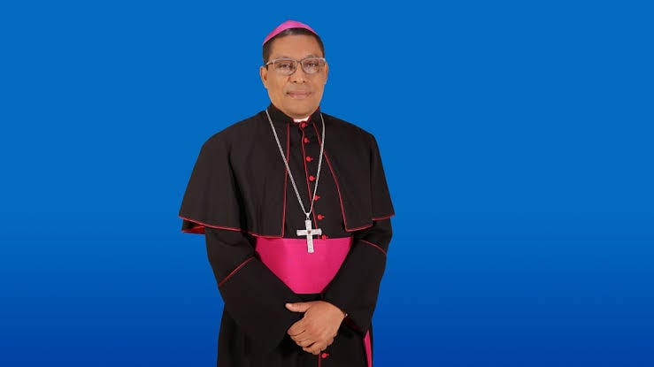 Hombre religioso con birrete rosa y sotana negra con detalles rosados, fondo azul. Hombre religioso con birrete rosa y sotana negra con detalles rosados, fondo azul.