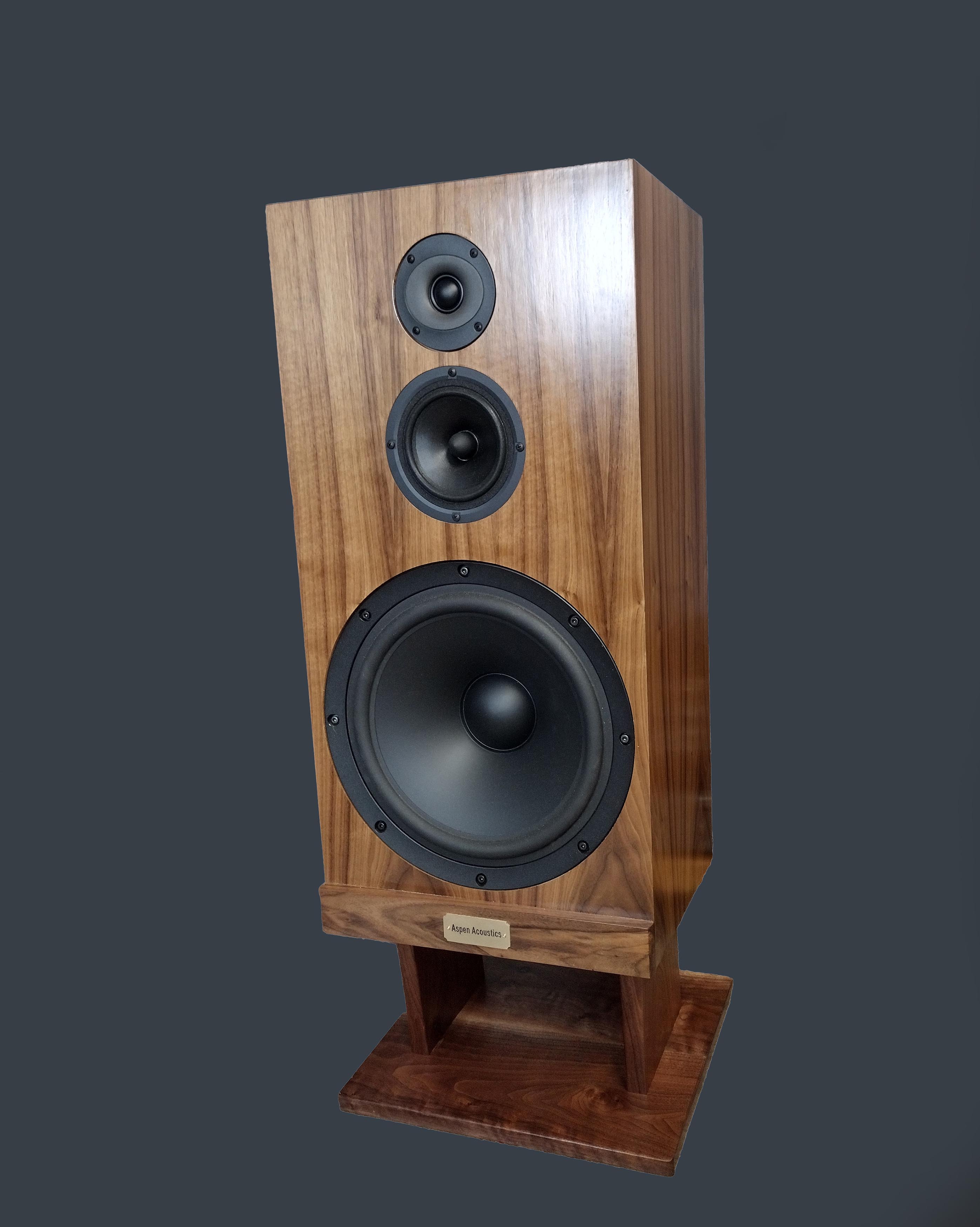 Pair of wooden floor-standing stereo speakers with multiple drivers on hardwood floor