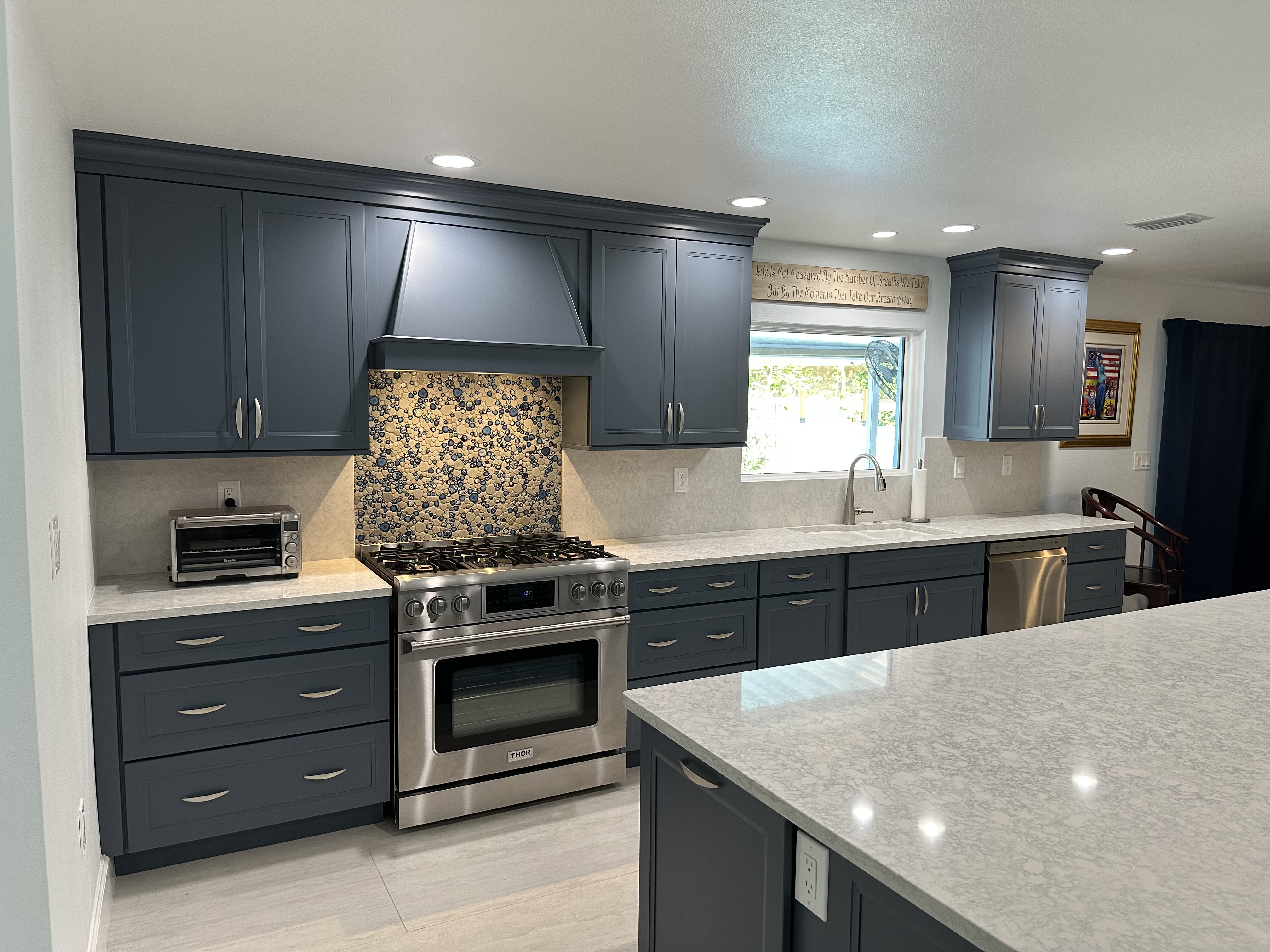 This beautiful kitchen features thoughtfully crafted semi-custom painted cabinets and rich Cambria countertops, creating a space that’s as functional as it is welcoming.