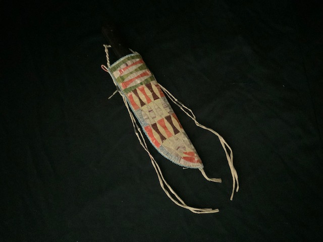 PRODUCT PROFILE :
Product No. : #11229
Description :  Sioux Quilled Knife
 sheath .
PRODUCT NARRITIVE:
•Native tanned knifes sheath  
with porcupine quills, green, 
purple, orange. 
•Circa: 1855-1860. Size: 10" length. 