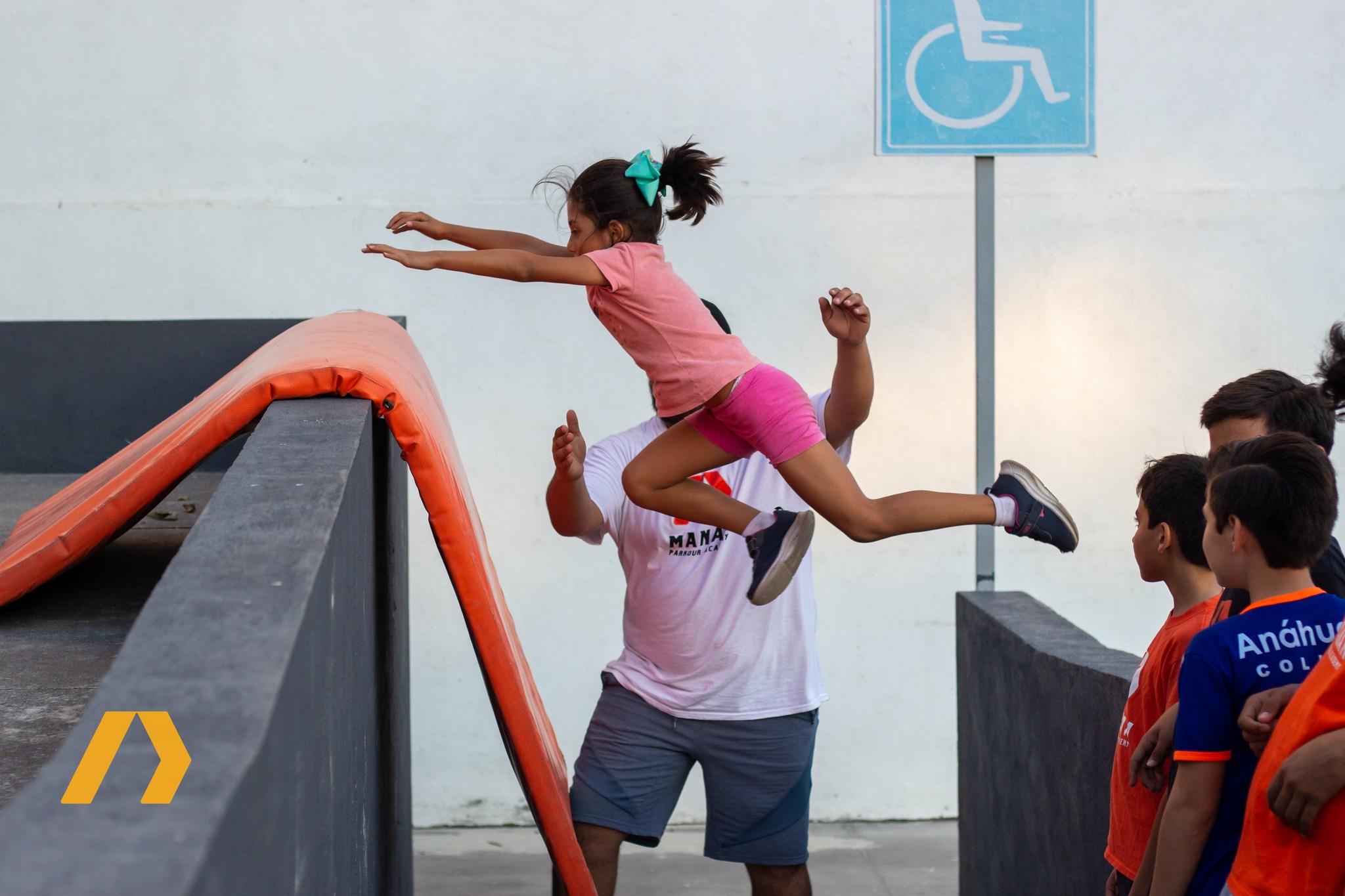 Niña practicando un salto de brazo