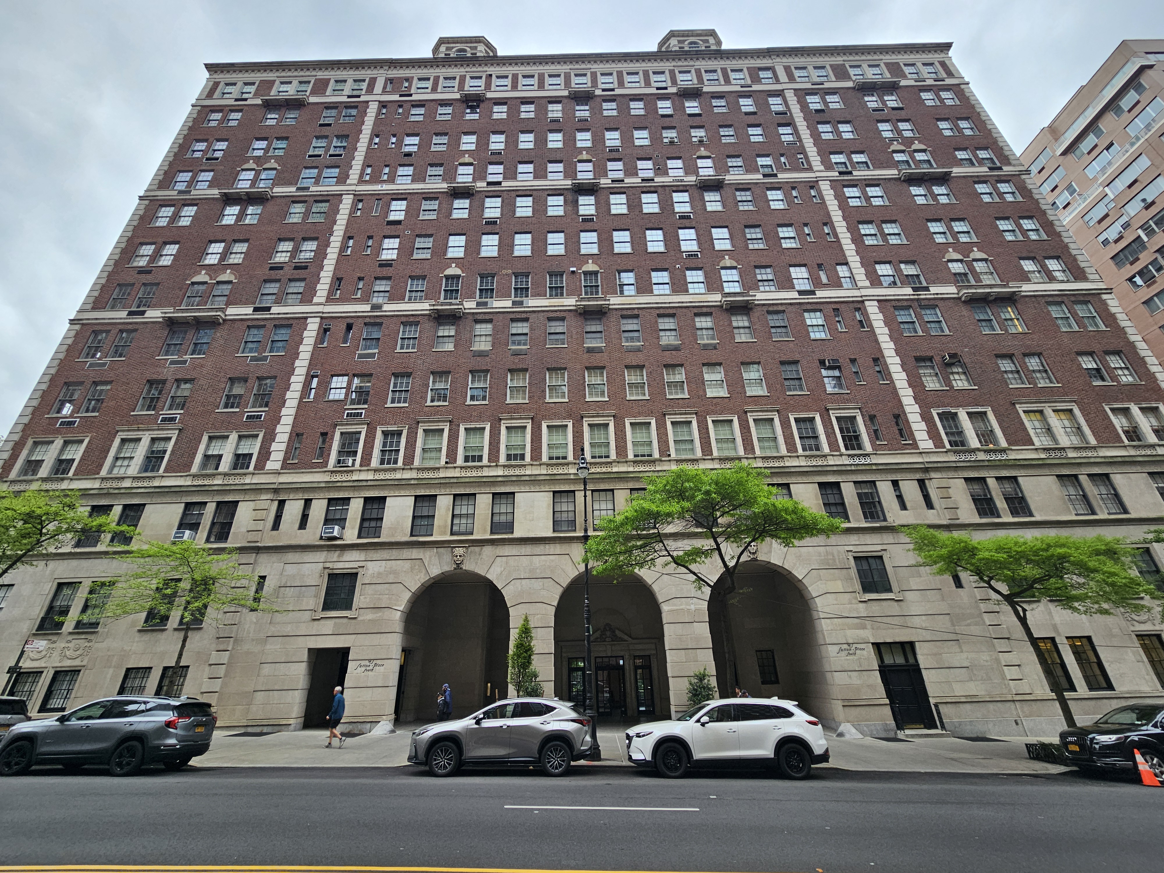 Large brick building with cars parked in front