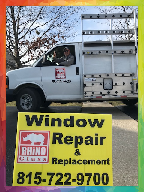 Modern living room with large windows, beige sectional sofa, orange cushions, indoor plant, and view of trees.