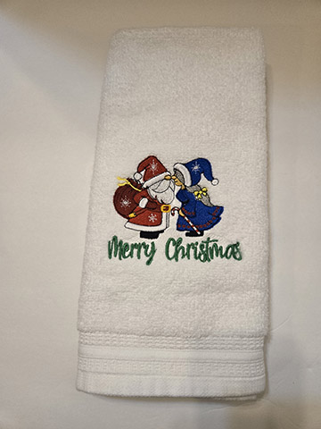 White hand towel featuring a Mr. and Mrs. Clause design