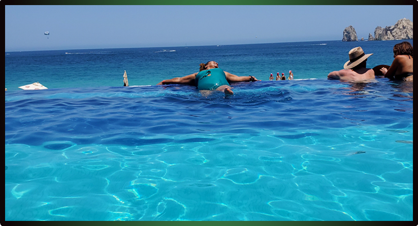 People relaxing in a pool near a body of water