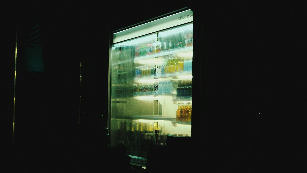Cocina moderna con estantes llenos de utensilios y un refrigerador grande con frutas y verduras iluminadas en su interior. Cocina moderna con estantes llenos de utensilios y un refrigerador grande con frutas y verduras iluminadas en su interior.