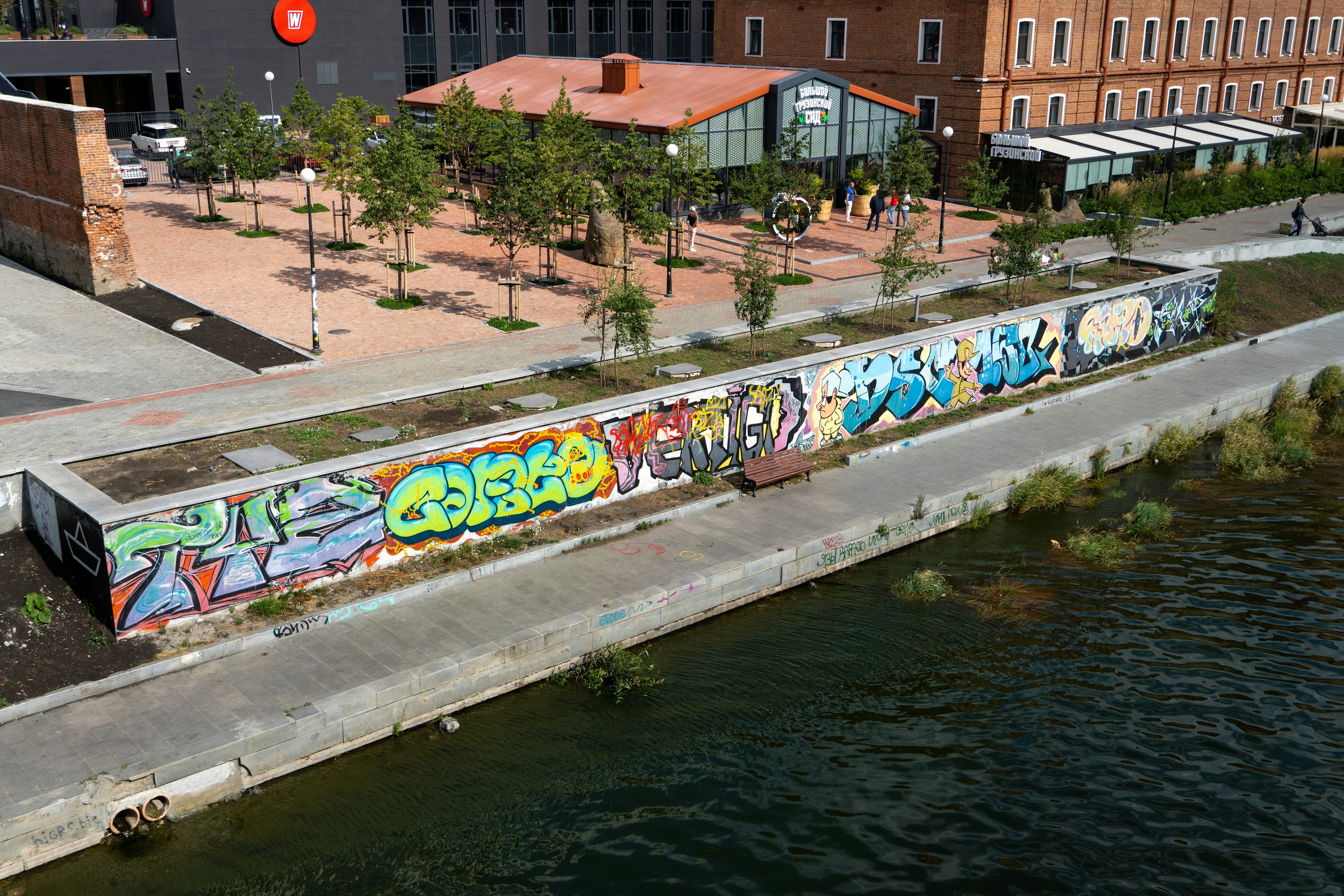 un cuerpo de agua con una pared con graffiti en ella