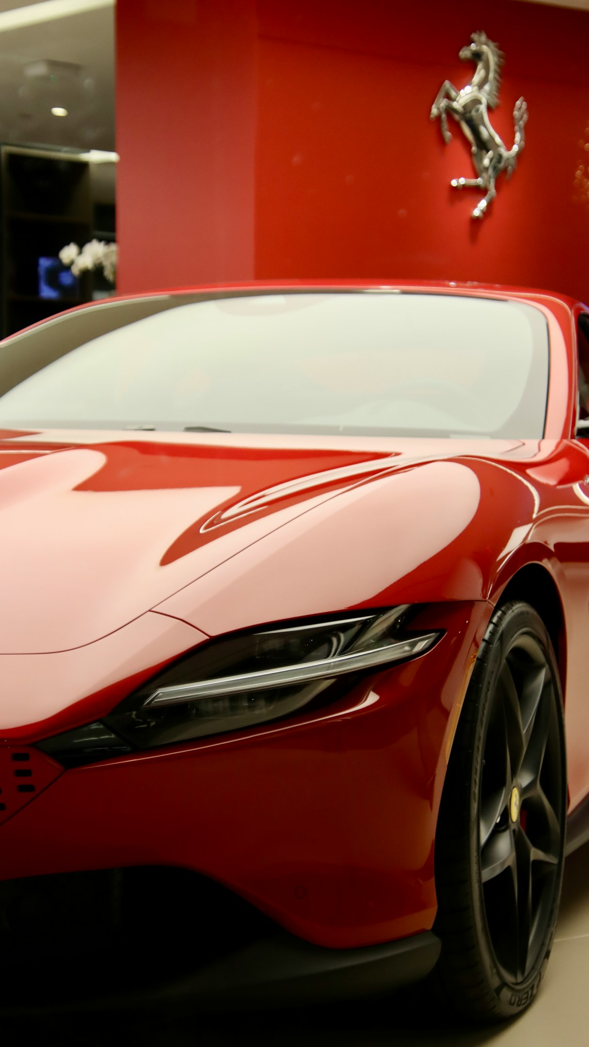 a red sports car parked in a showroom
