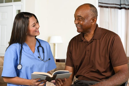 Health Care Worker and Elderly Patient Reading Book