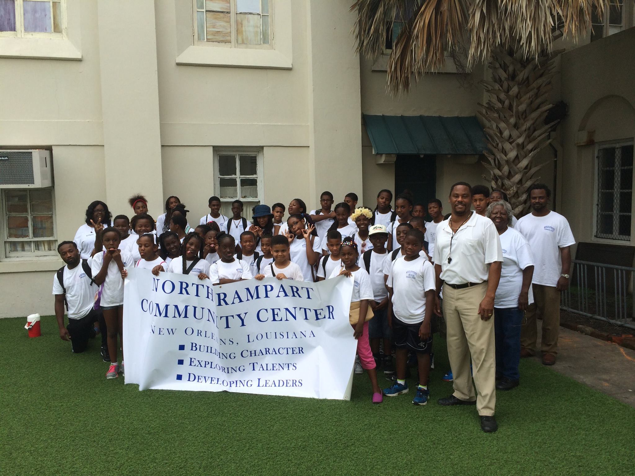 Diverse group of young adults happily collaborating on laptops in a bright, modern office setting.