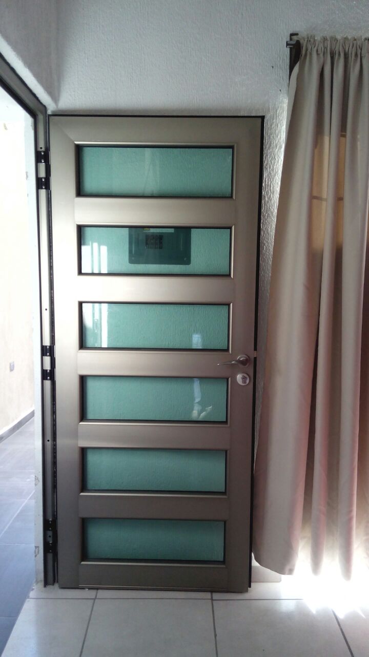 Puerta de vidrio y aluminio en tono champagne (línea española).