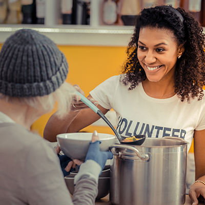 Lady serving food as Volunteer