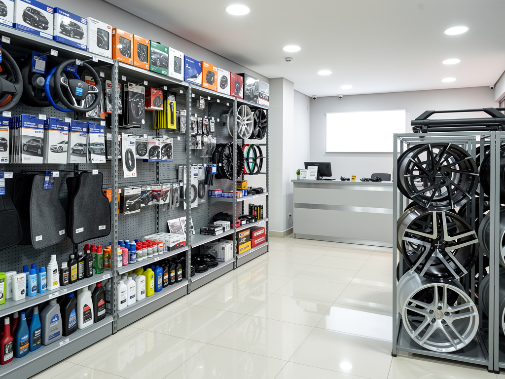 Tienda de accesorios para autos con estantes de volantes, productos de limpieza, tapetes y exhibidor de llantas deportivas