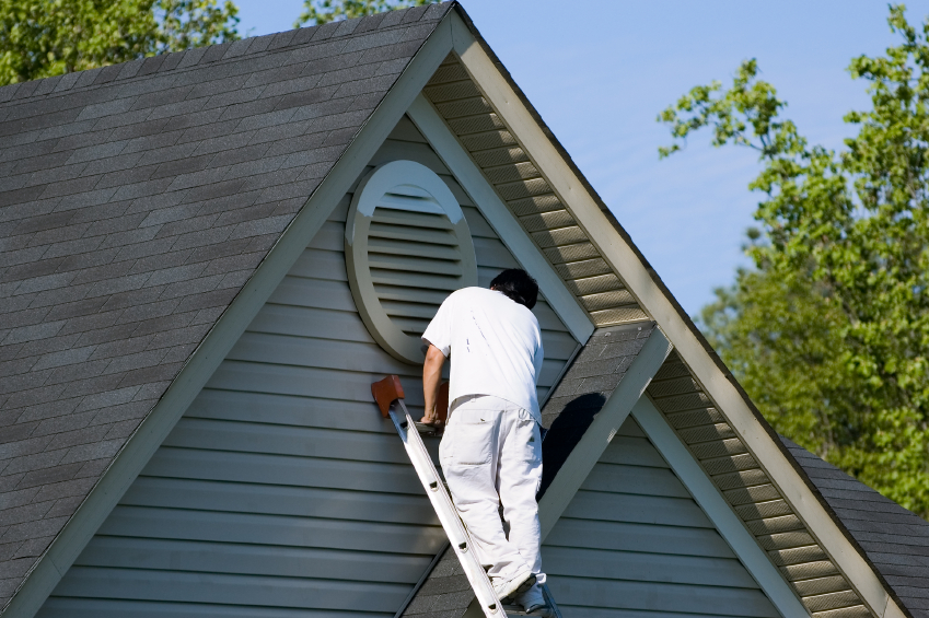 Painter working at roofline Painter working at roofline