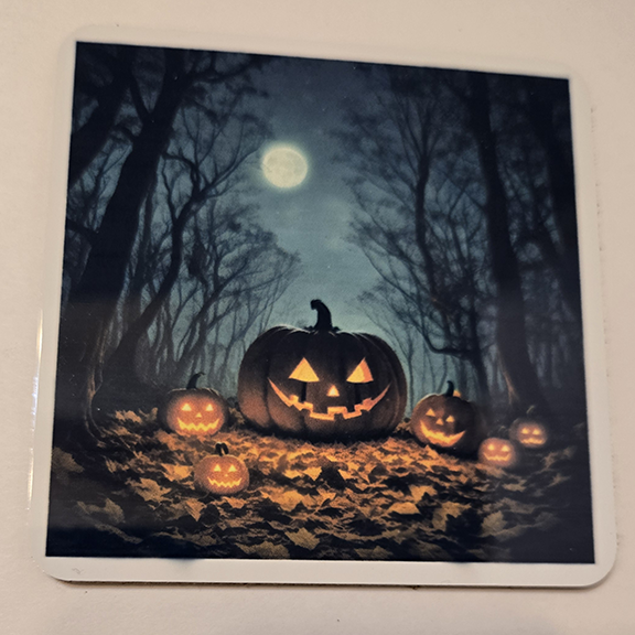 Square metal coaster with a pumpkins at night design
