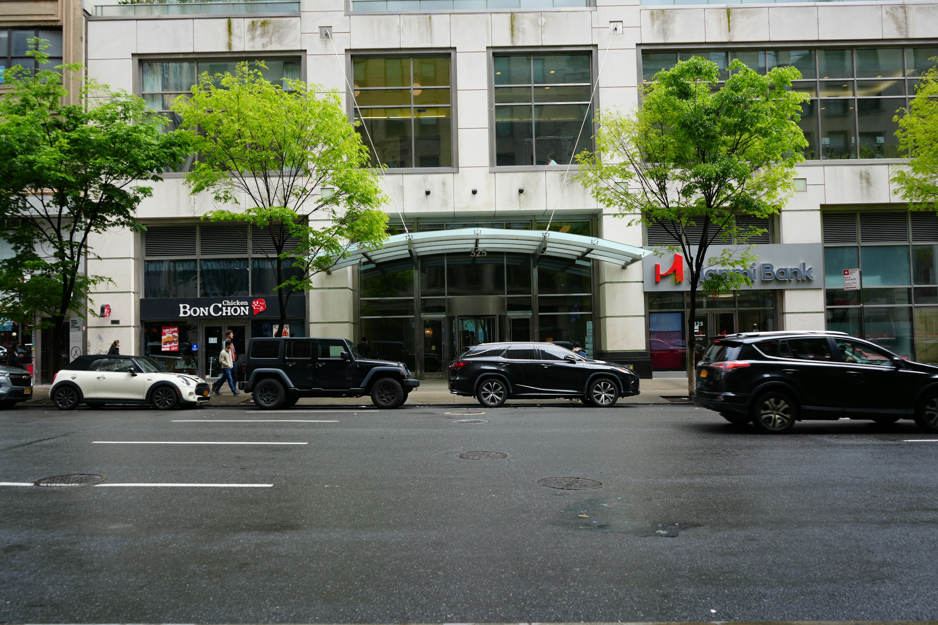 a city street filled with lots of traffic next to a tall building