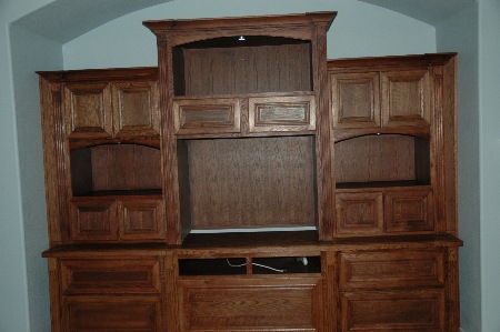 Handcrafted media center is made of
 hand rubbed stains. It features arches,
 varying depth and higths of cabinets, fluted
 columns, capitals, releif crown, and high
intensity lights for display areas.