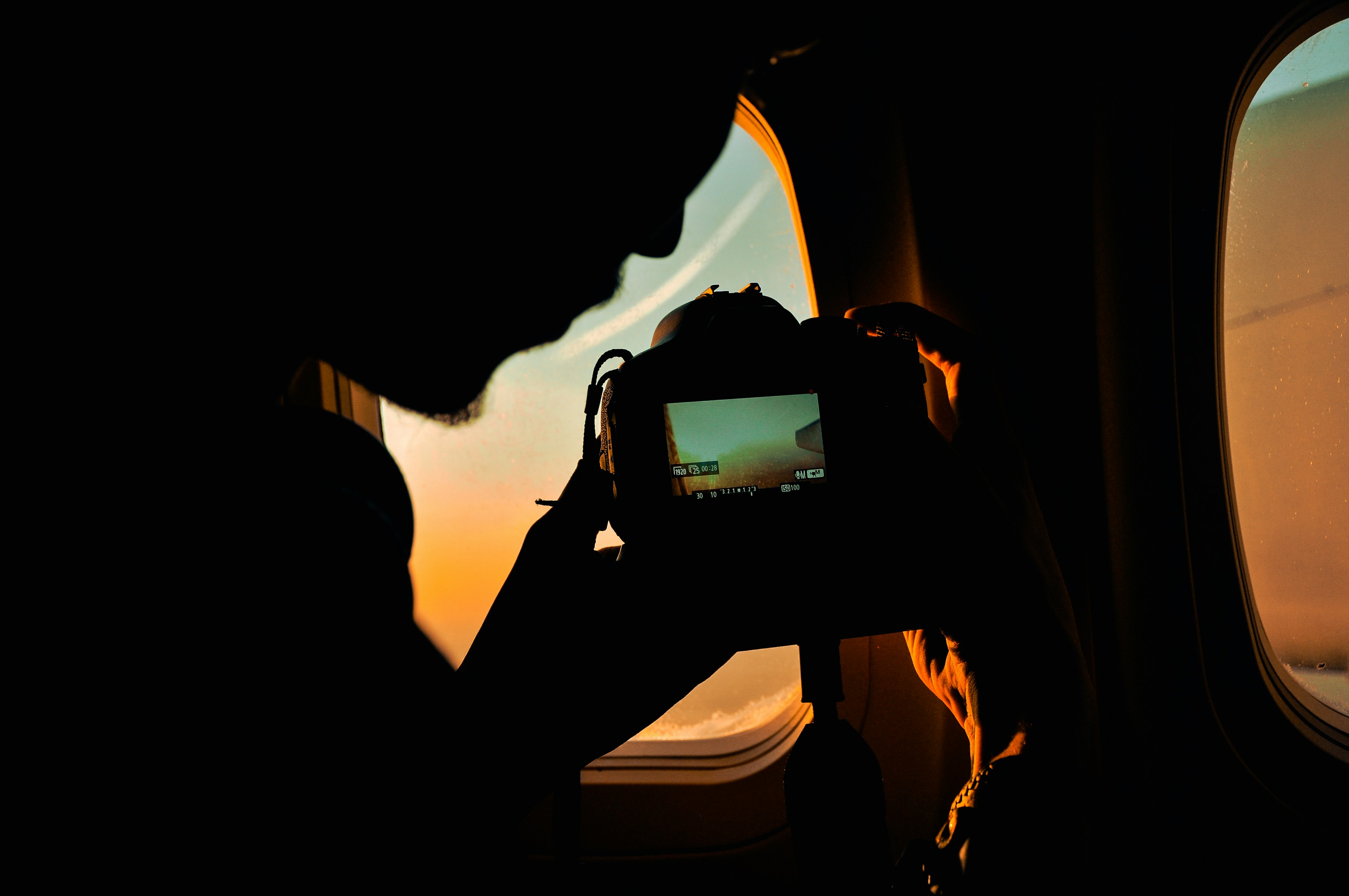 a person taking a picture of a plane window