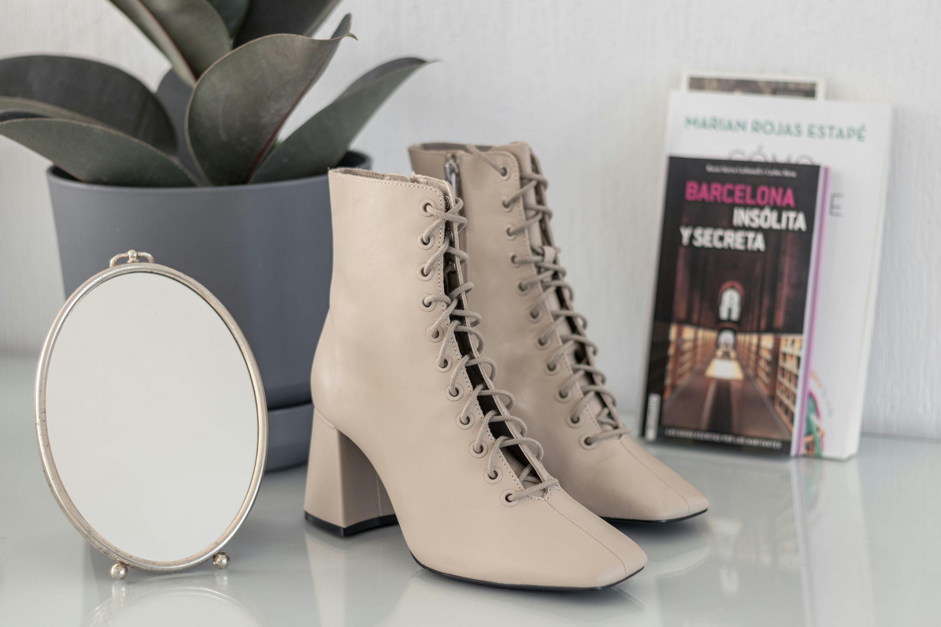 botas de cuero marrón sobre mesa blanca