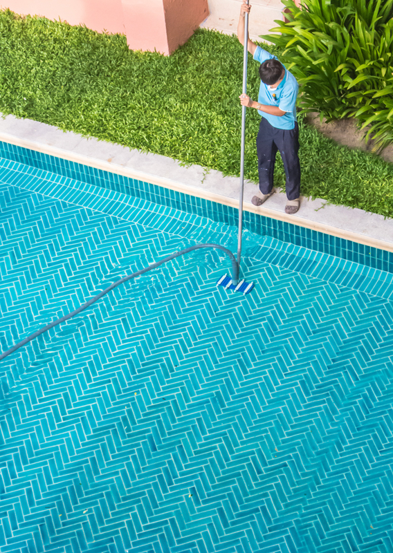 Worker cleaning the pool Worker cleaning the pool
