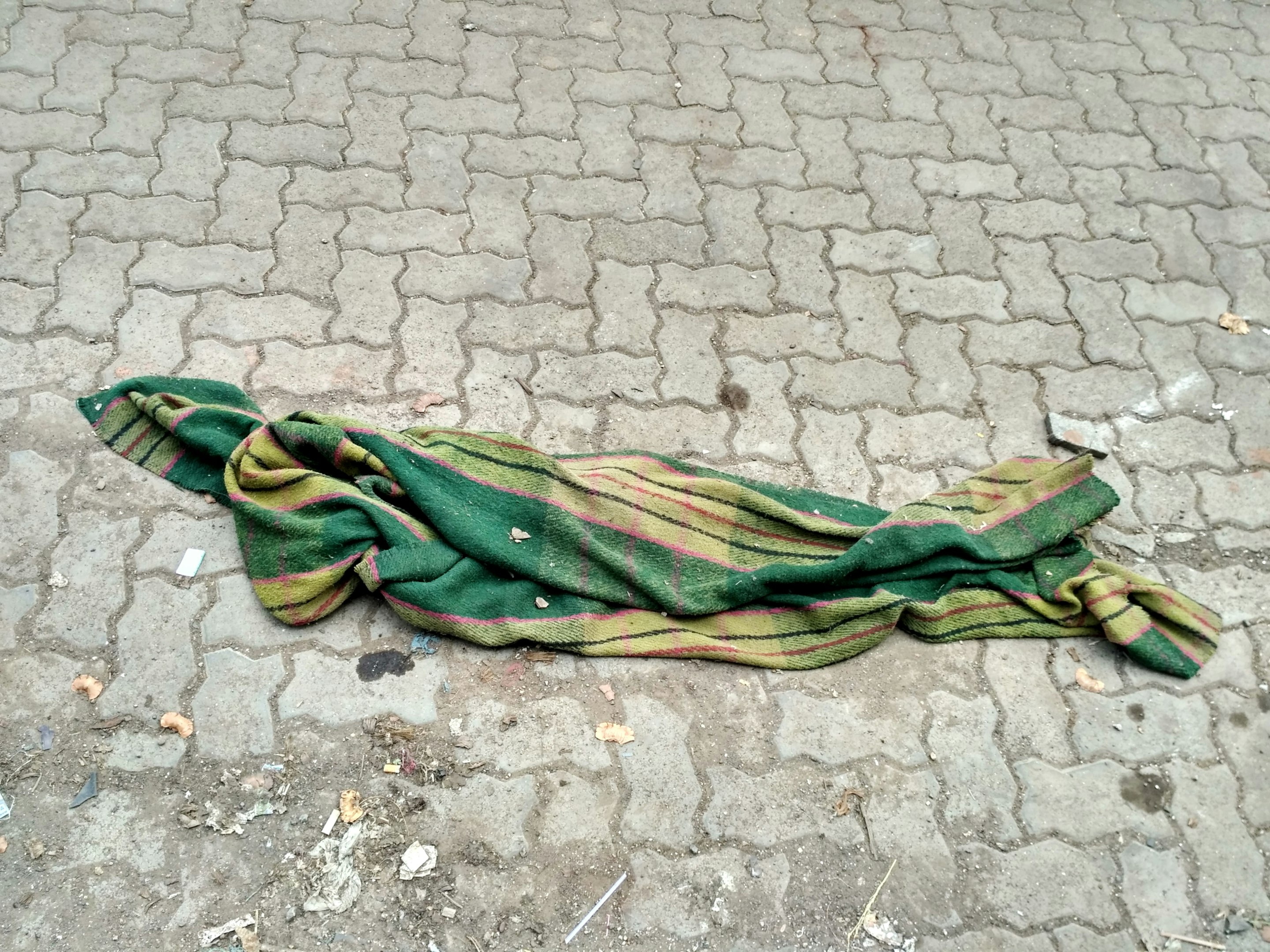 Un paraguas verde y amarillo tirado en el suelo