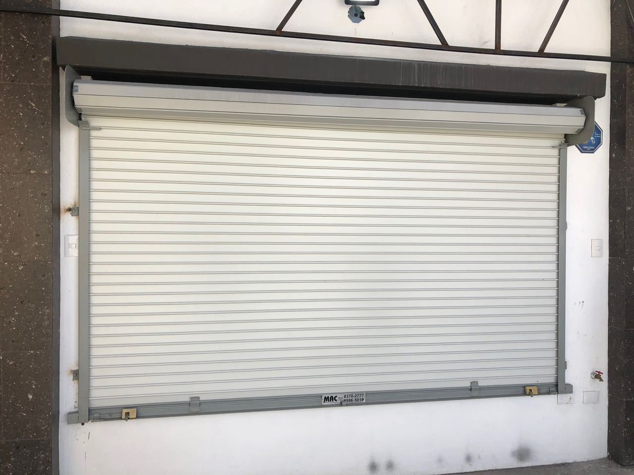 Cortina de acero fabricada en lamina duela plana pintro blanca cal.24 con mecanismo de impulso 