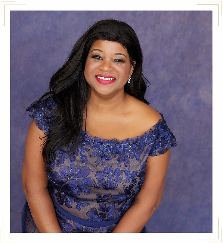 Pastor Teka wearing a purple shirt and smiling