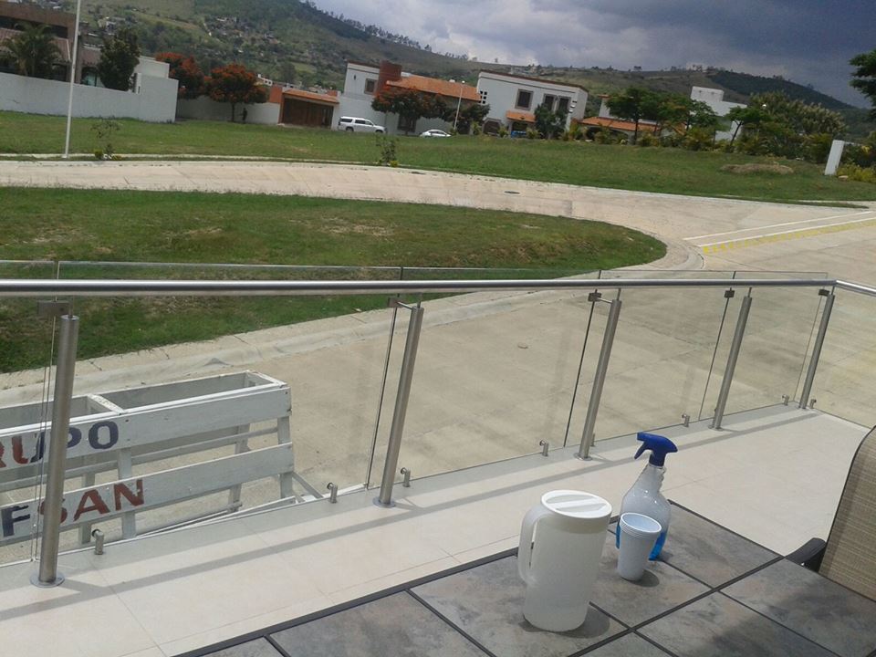 Barandal de cristal templado de 9mm, con postes y pasamanos de acero inoxidable.