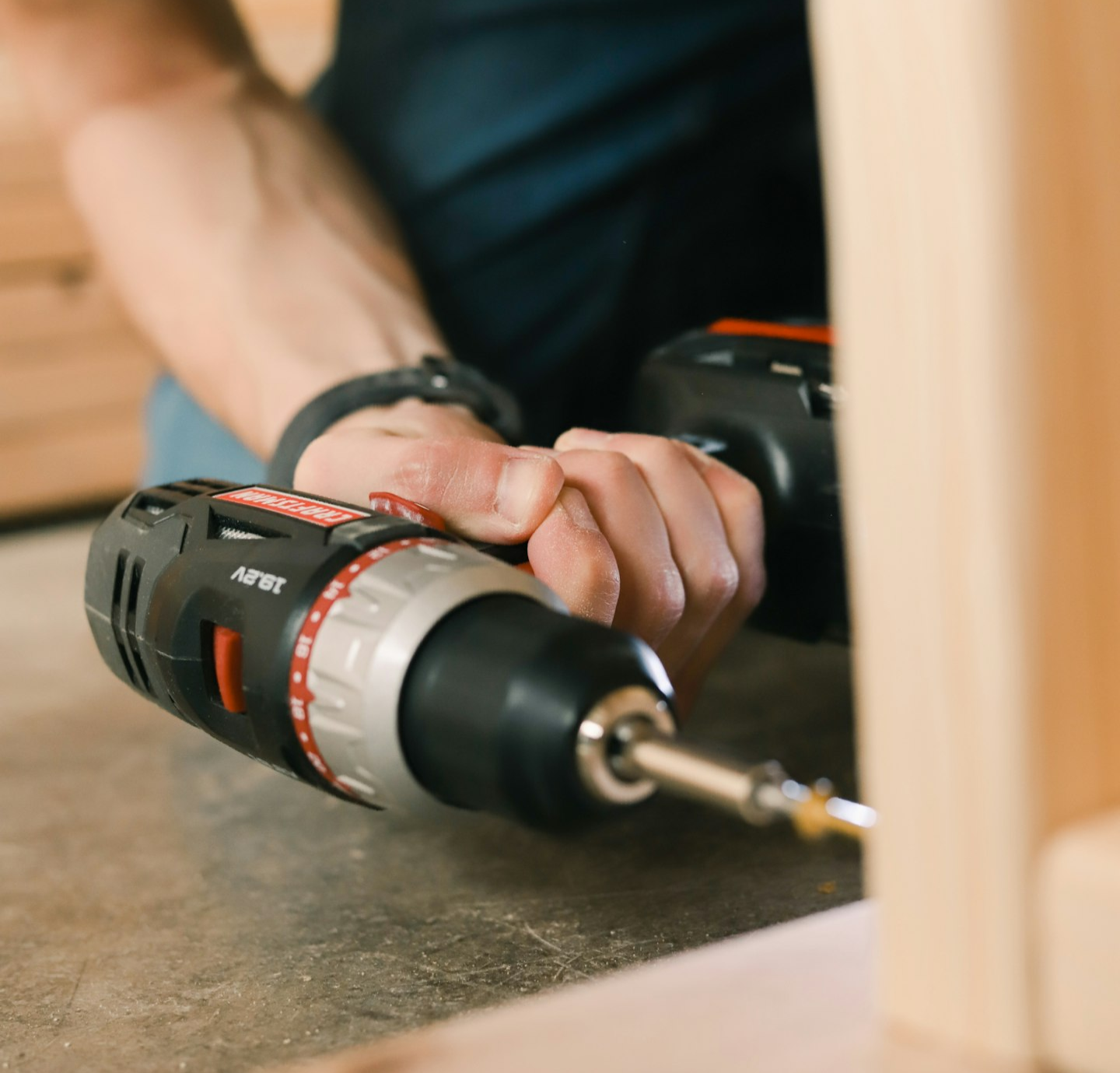 person holding black and red cordless hand drill