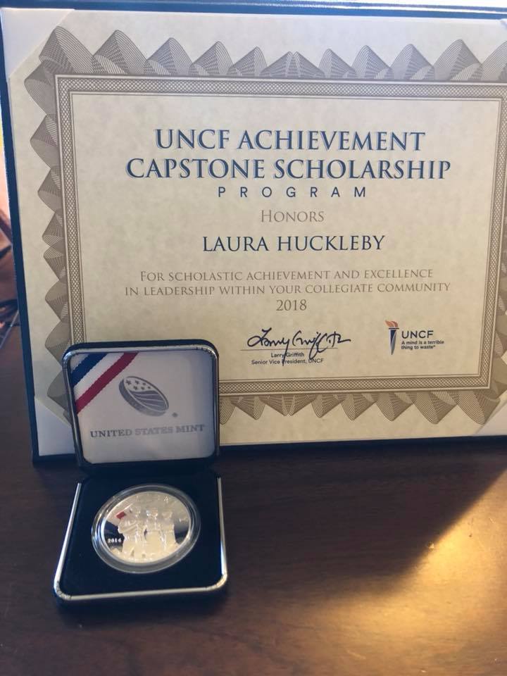 Home office desk with a laptop displaying a rising bar graph, surrounded by plants, books, and coffee cup.