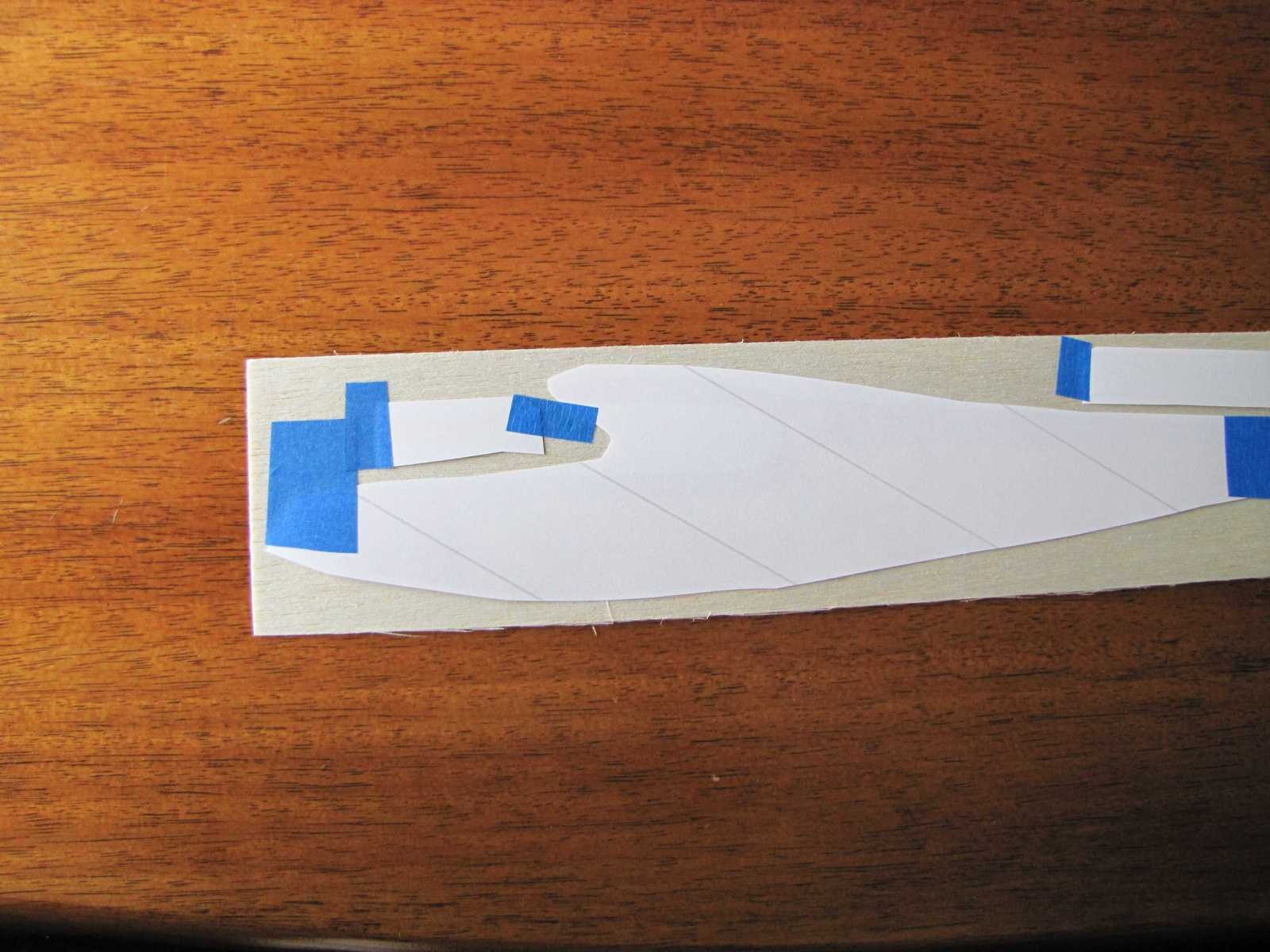 Place the printed parts on your sheet of balsa. Any thickness balsa sheet can be used. The example shown is 1/32" balsa sheet. Some tape may be useful in keeping them in position. It is important that the transfer paper not move while it is being ironed or the parts will blur.