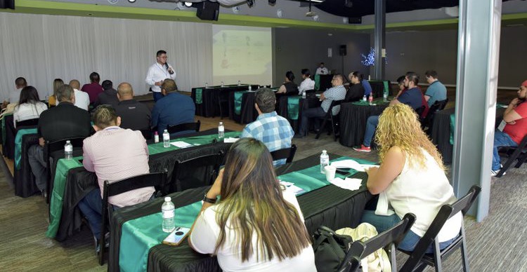 Conferencia empresarial con participantes sentados y presentador en pantalla. Conferencia empresarial con participantes sentados y presentador en pantalla.