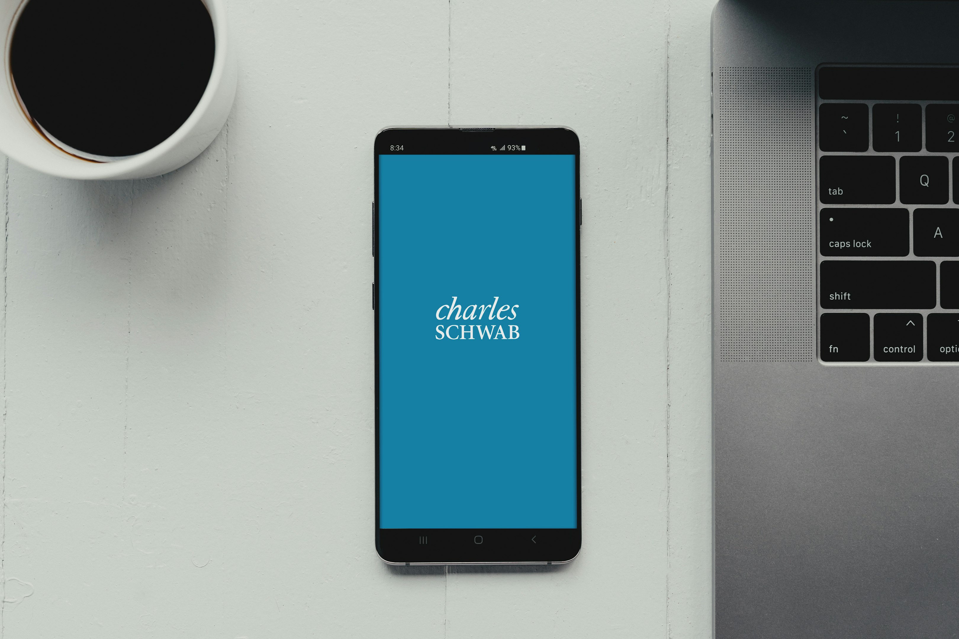 un teléfono celular sobre un escritorio junto a una computadora portátil