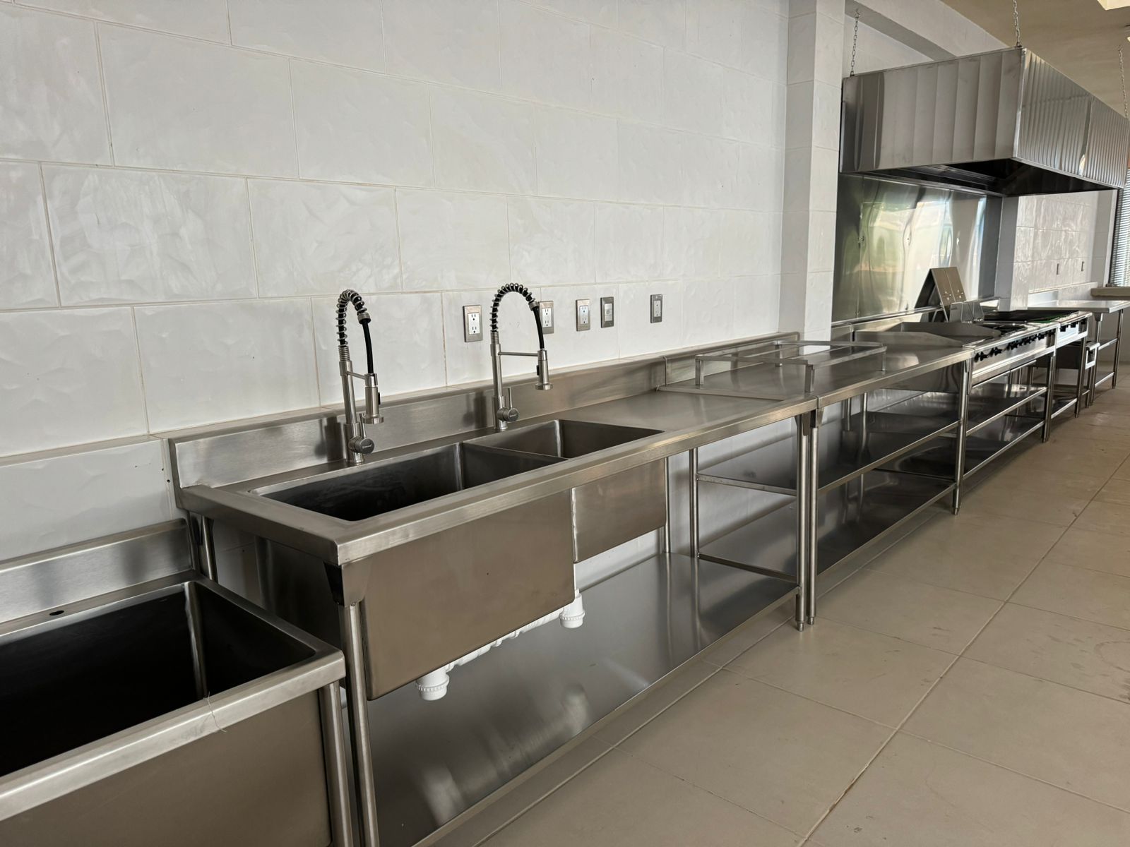 Pasillo de supermercado con refrigeradores llenos de productos variados y personas al fondo.