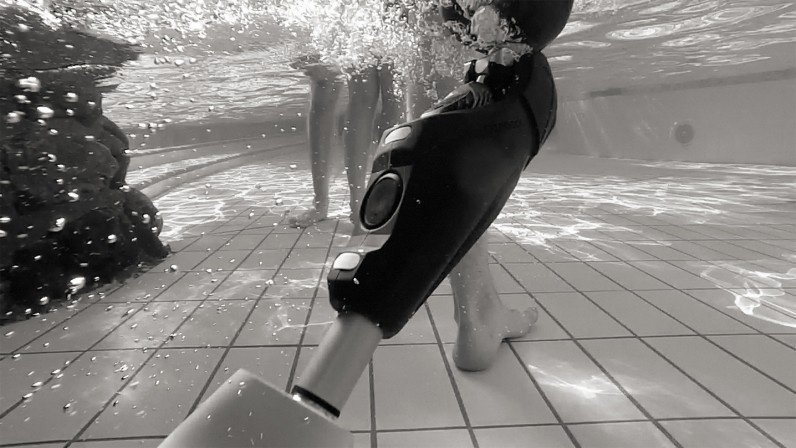 Underwater view of person wearing a prosthetic leg standing in swimming pool