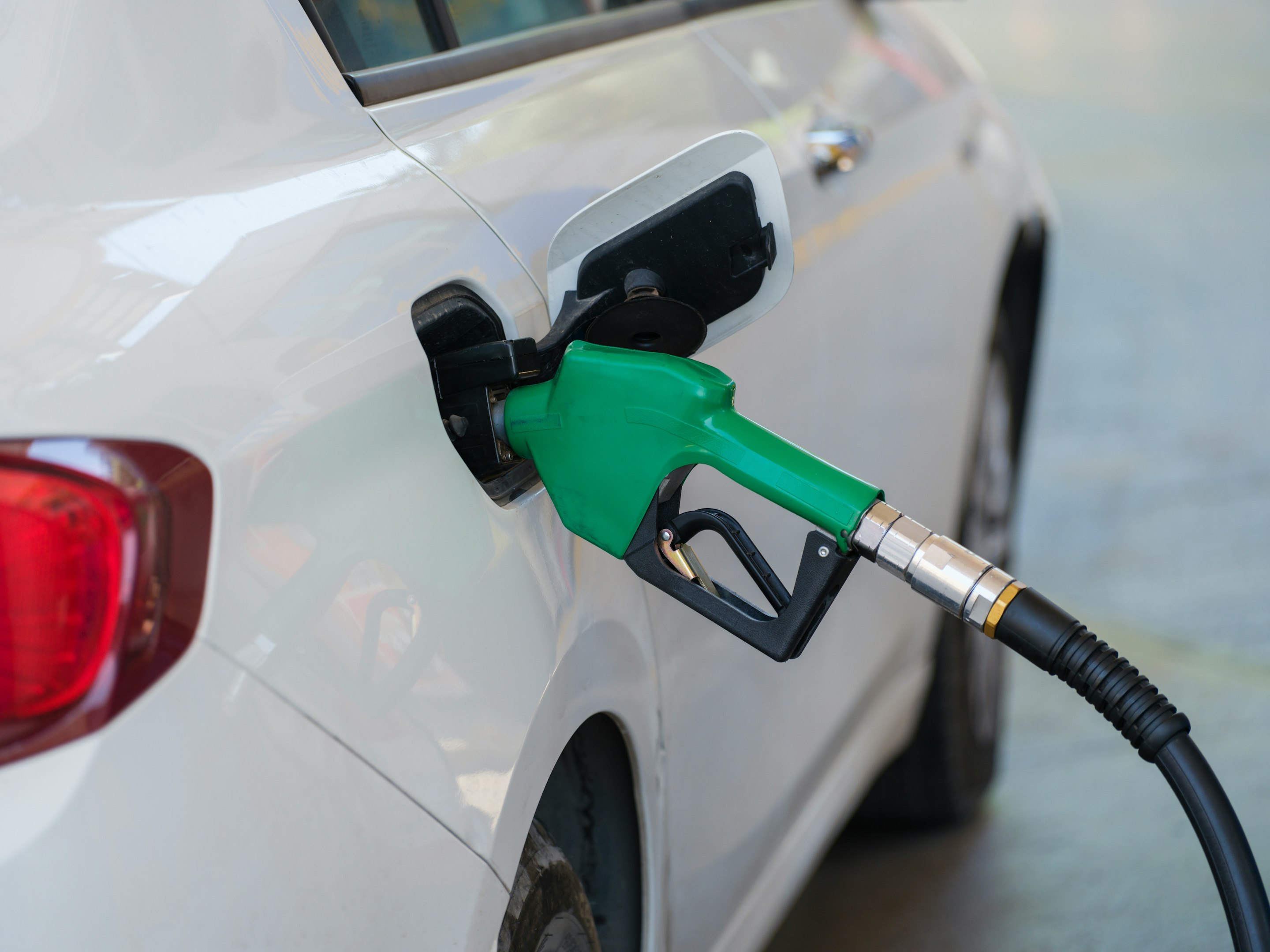 un coche blanco con una bomba de gas verde