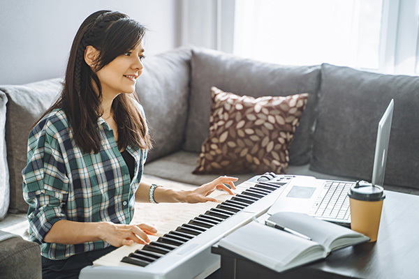 Young woman music playing electric piano