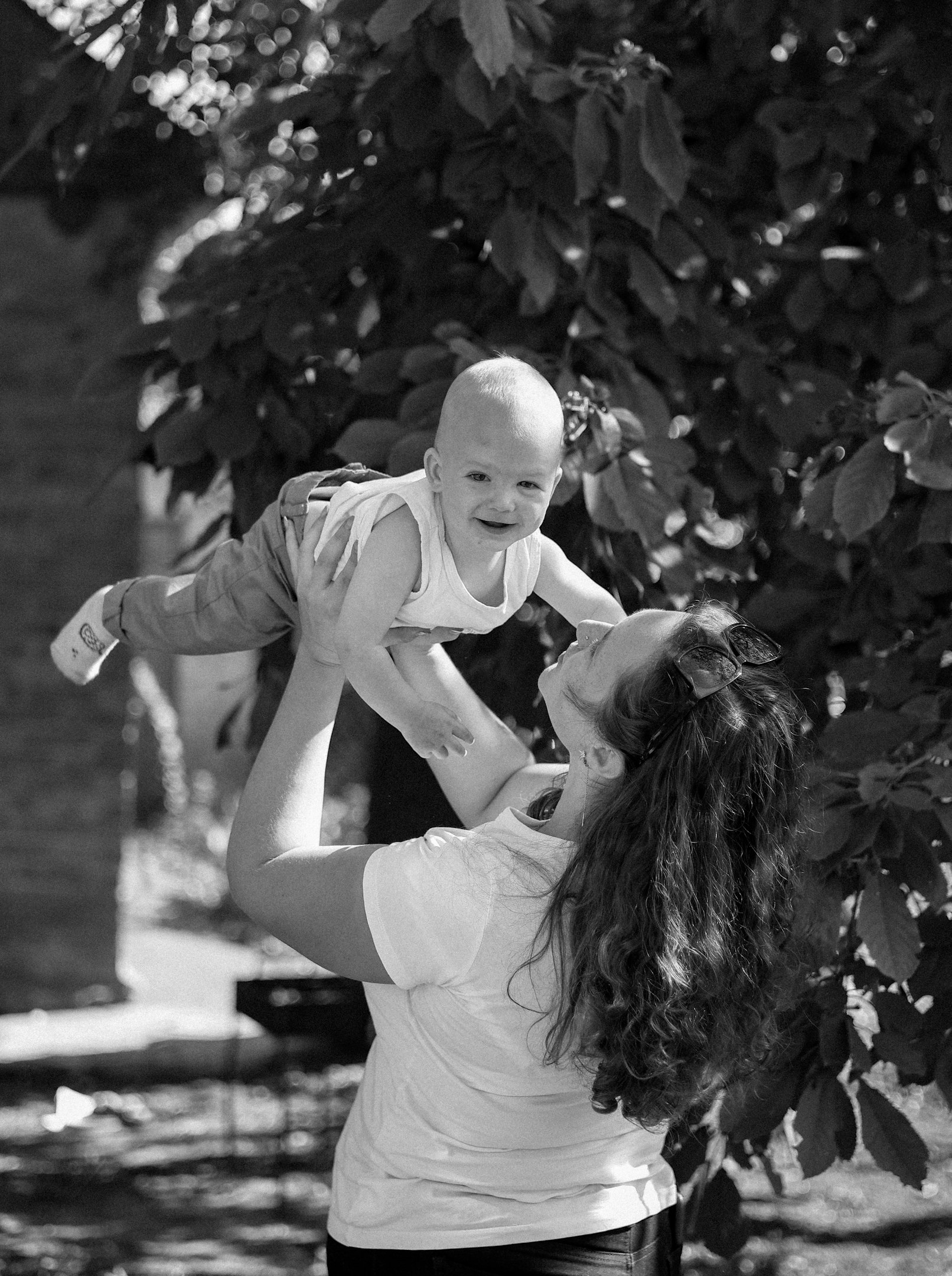 a woman holding a baby up in the air